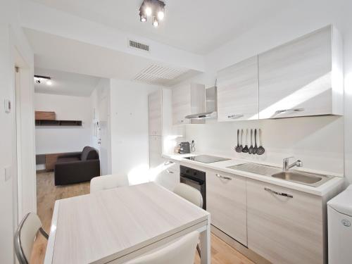 a white kitchen with a sink and a table at Gentilè in Bari