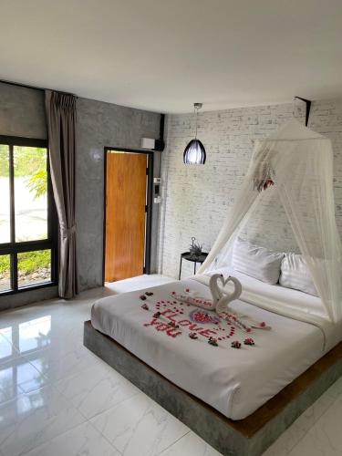 a bedroom with a bed with roses on it at Phumaihom Resort in Hat Yai