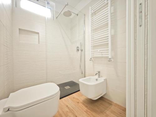 a white bathroom with a toilet and a sink at Gentilè in Bari