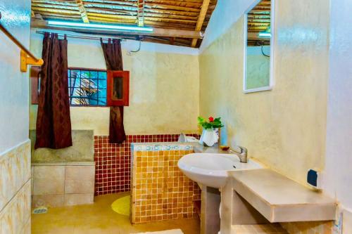 a bathroom with a sink and a window at VILLA AMNESYA NOSY BE in Nosy Be