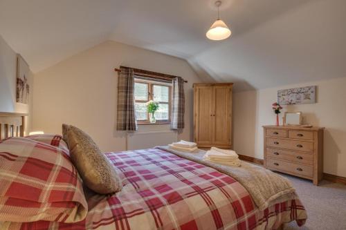 a bedroom with a bed and a dresser and a window at 3 Bed in South Molton oc-millba in Bishops Nympton