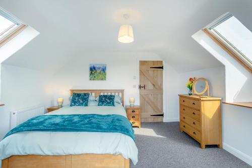 a bedroom with a bed and a dresser and a window at 3 Bed in Bish Mill oc-e30946 in Bishops Nympton