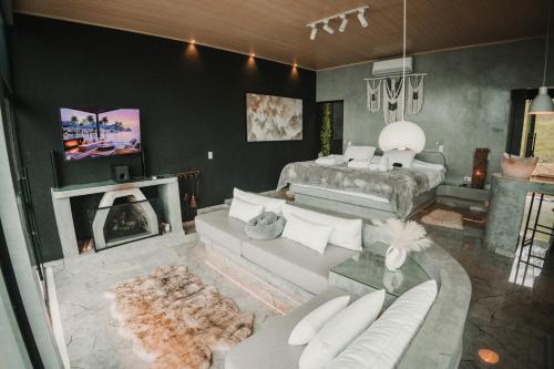 a living room with a couch and a bed at Chalé Boutique - Spa - Sauna seca , Jacuzzi , Rede suspensa in Campos do Jordão