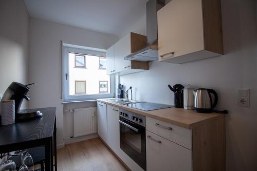 a small kitchen with a stove and a window at Glanzvoll, moderne Wohnung in Aschaffenburg