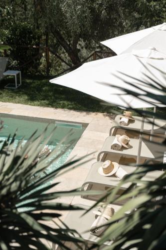a row of lounge chairs with umbrellas next to a swimming pool at Tenuta dei Normanni in Salerno