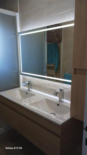 a bathroom with a sink and a large mirror at Mandelieubeach06 in Mandelieu-La Napoule