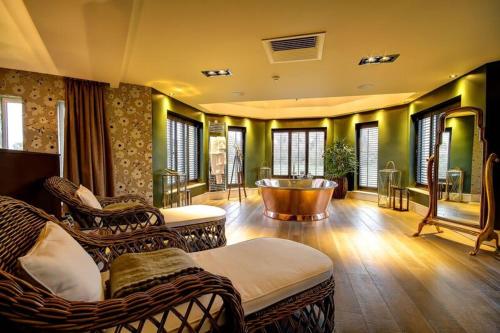 a living room with wicker chairs and a tub at Ramside Hall Hotel, Golf & Spa in Durham