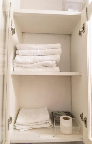 a closet with white towels on a shelf at Apartamento 32 Juana de Arco in Quito