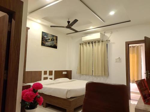 a bedroom with a bed and a ceiling fan at Infinity inn in Guna