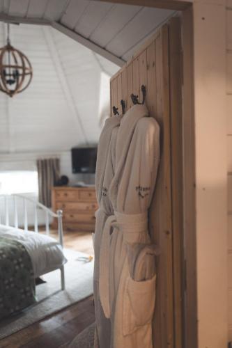 a robe hanging on a wall in a bedroom at 2 - Luxury Escape - Outdoor bathtub and sauna under the stars! in Pont Sticill