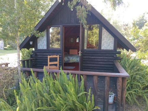a cabin in the woods with a wooden deck at Tannenhof Countryside Log Cabins in Sanddrif