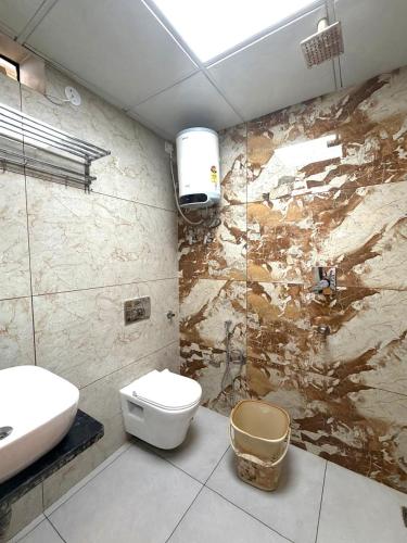 a bathroom with a white toilet and a sink at GRACE Inn in Dehradun