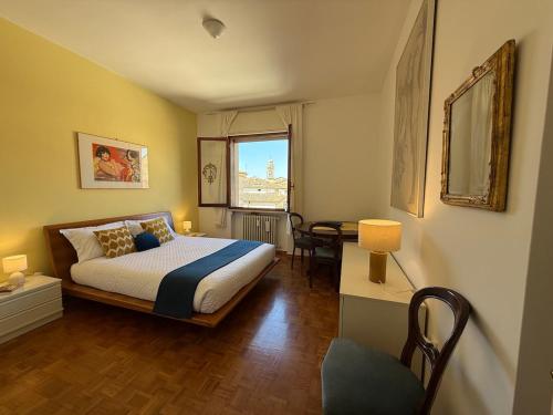a bedroom with a bed and a table and a window at L' Atelier sui Tetti in Faenza