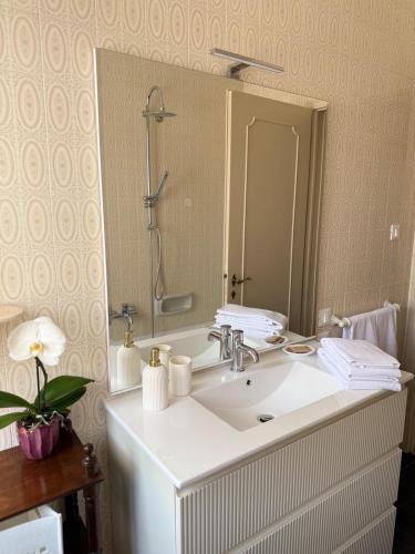 a bathroom with a white sink and a mirror at L' Atelier sui Tetti in Faenza