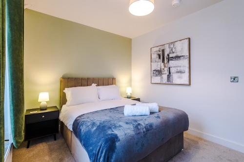 a bedroom with a bed with a blue blanket at Spring Mount - 3 Bedrooms - Close to Convention Centre in Harrogate