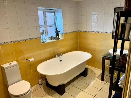 a bathroom with a tub and a toilet and a sink at 2 Bed Duplex Penthouse Apartment by Mathew Street Sleeps 6 in Liverpool