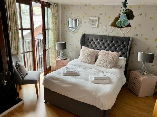 a bedroom with a large bed and a chair at 2 Bed Duplex Penthouse Apartment by Mathew Street Sleeps 6 in Liverpool