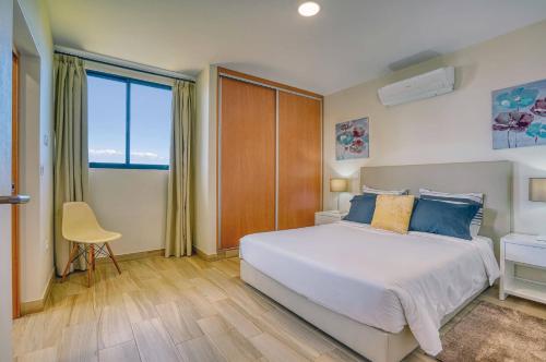 a bedroom with a large bed and a large window at Refugio do Sol - Madeira Inn Group in Calheta
