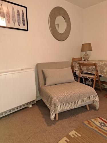 a living room with a ottoman and a mirror at Katrinas Apartment By Treetop Property in Cirencester