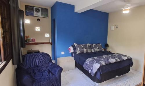 a bedroom with a bed and a blue wall at Rancho e Pesqueiro do Cowboy in Piedade