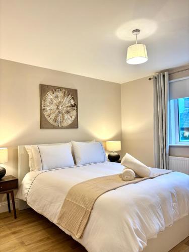a bedroom with a large white bed and a window at Cobh Panorama- Sea & Cathedral Views in Cobh