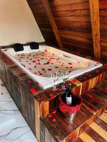 a wooden bath tub with wine glasses and a bed at Pousada Vasto Horizonte in Barreirinhas