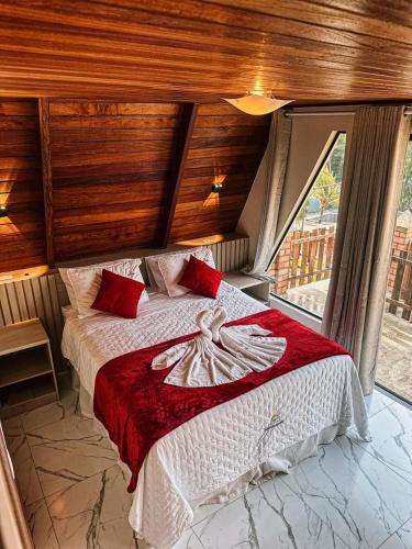 a bedroom with a large bed with red pillows at Pousada Vasto Horizonte in Barreirinhas
