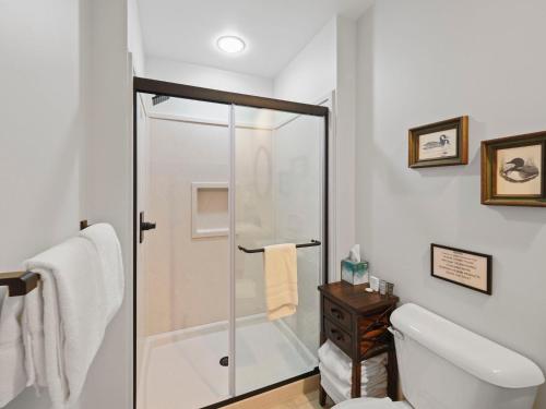 a white bathroom with a shower and a toilet at 692 Disciples Village Condo in Boyne Falls