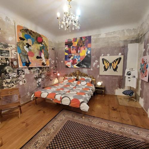 a bedroom with a bed and paintings on the walls at Crystal Ball Residency in Berlin