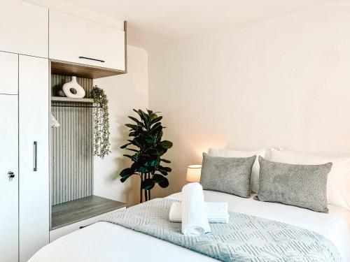 ein Schlafzimmer mit einem weißen Bett und grauen Kissen in der Unterkunft Ebb & Flow in Hermanus