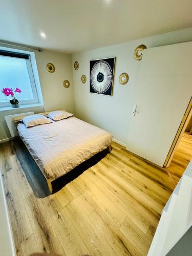 a bedroom with a bed and a window at Appartement moderne et chaleureux in Mutrécy