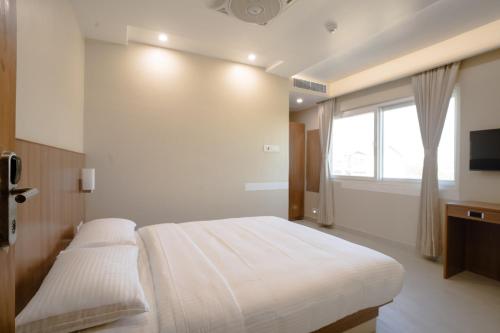 a bedroom with a large bed and a window at Hotel Orchid Imphal in Imphal