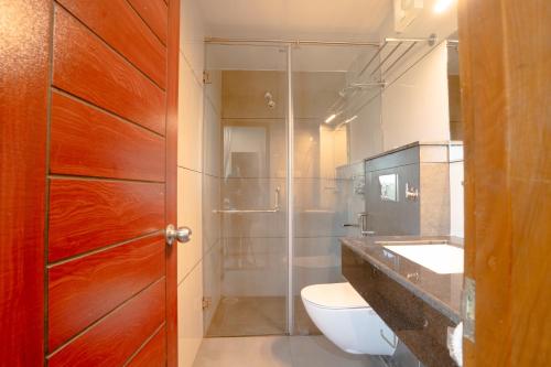 a bathroom with a toilet and a sink and a shower at Hotel Orchid Imphal in Imphal