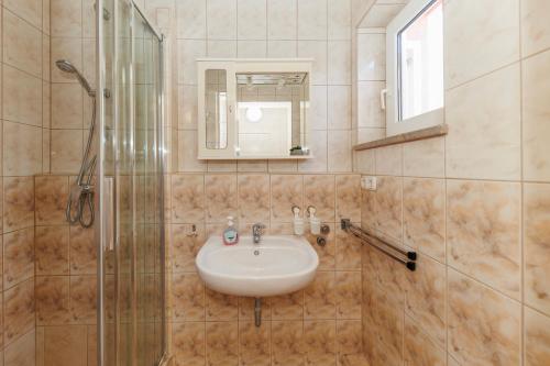 a bathroom with a sink and a shower at Villa Apolonija in Zadar