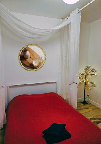 a bedroom with a red bed and a mirror at L'écrin médiéval in Fougères
