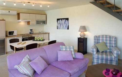 a living room with a purple couch and a kitchen at Istron Collection Villas in Istron