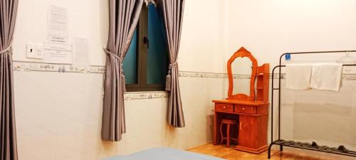 a bathroom with a bed and a mirror and curtains at Đức Phát Homestay in Tân Phú