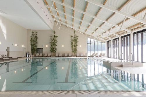 a large swimming pool in a building with windows at Ramside Hall Hotel, Golf & Spa in Durham