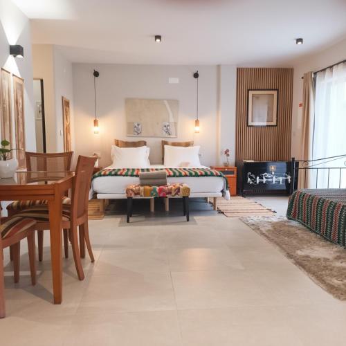 a bedroom with a bed and a table and chairs at Casa do Campinho B&B boutique guest house in Reguengos de Monsaraz