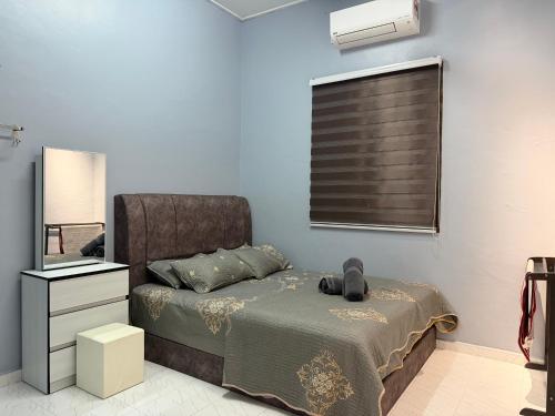 a bedroom with a bed with a teddy bear on it at Homestay De Acacia Rumah Melati in Kuala Terengganu