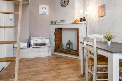 Old town flat في أنِسي: غرفة معيشة بها مدفأة وطاولة وكراسي