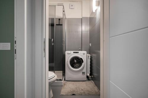 a bathroom with a washing machine and a toilet at Assago Forum Apt - 3 min Walk in Assago