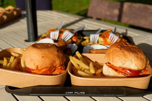 two sandwiches and french fries on a table at Thrill Playgrounds & Tipi Cafe in Libona
