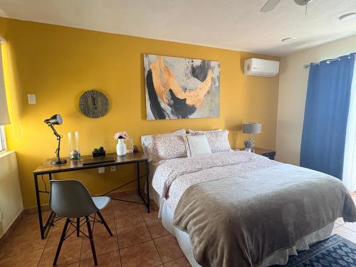a bedroom with a bed and a desk and a clock at Casa Lauren Del Sol en Zona Dorada de Tampico in Tampico