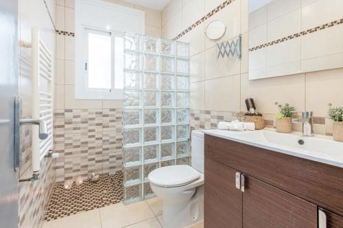 a bathroom with a toilet and a shower and a sink at Piscina, mar y centro – Casa ideal para familias in Empuriabrava