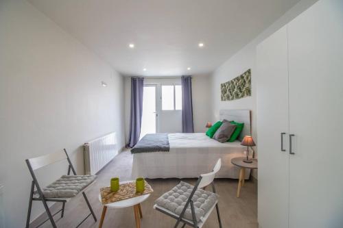 a bedroom with a bed and two chairs and a table at Piscina, mar y centro – Casa ideal para familias in Empuriabrava