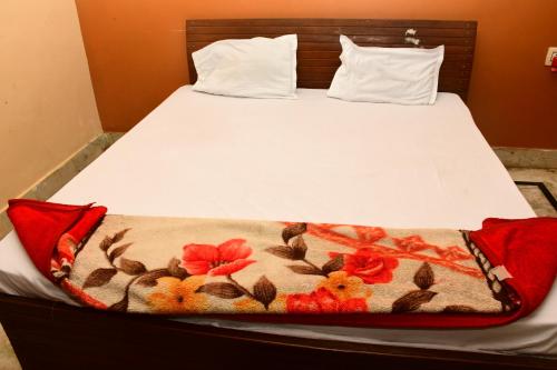 a bed with a blanket on top of it at Hotel Sampark in Bhadrak