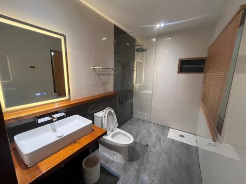 a bathroom with a sink and a toilet and a mirror at บ้านซินอัน in Ban Rak Thai