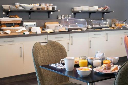 ein Tisch mit Frühstücksspeisen darauf in einer Küche in der Unterkunft Brit Hotel Bressuire in Bressuire
