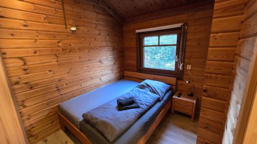 a small room with a bed in a wooden cabin at Das Haus Kaninchenhöhle in Dankern